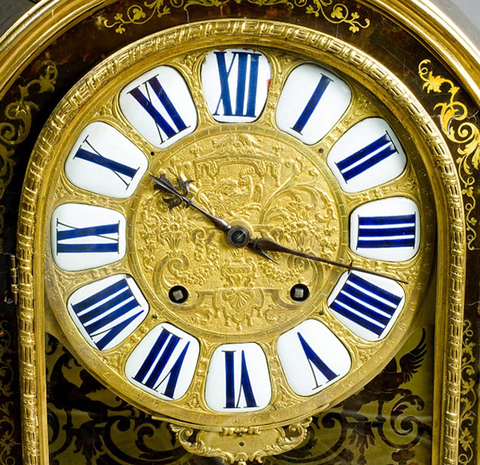 Ornate gold clock face with dark blue roman numerals